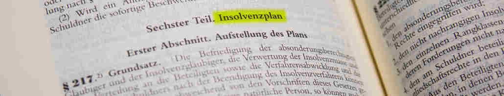 Aufgeschlagenes Gesetzbuch. Wichtiger Paragraph zum Insolvenzplan ist markiert.