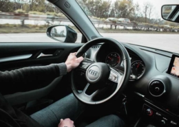 Bild von Lenkrad und Armaturenbrett eines Autos auf der Autobahn