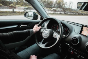 Bild von Lenkrad und Armaturenbrett eines Autos auf der Autobahn