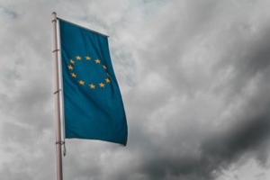 Bild von einer europäischen Flagge vor grauen Wolken