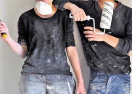 Bild von zwei Handwerkern mit Hammer und Farbrolle in der Hand