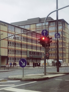 Bild von einer roten Ampel und Verkehrszeichen zur vorgegeben Fahrtrichtung
