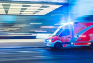 Krankenwagen rast mit Blaulicht die Straße entlang