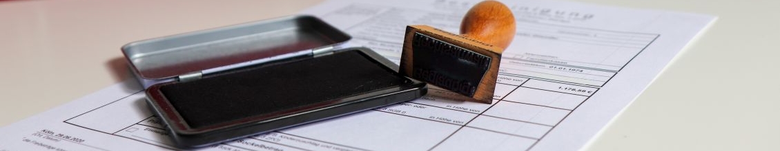 KGR_Insolvenzrecht_Slider2_1130x375 Das Bild zeigt ein Dokument und einen Stempel