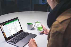 Bild von Person am Laptop und Handy